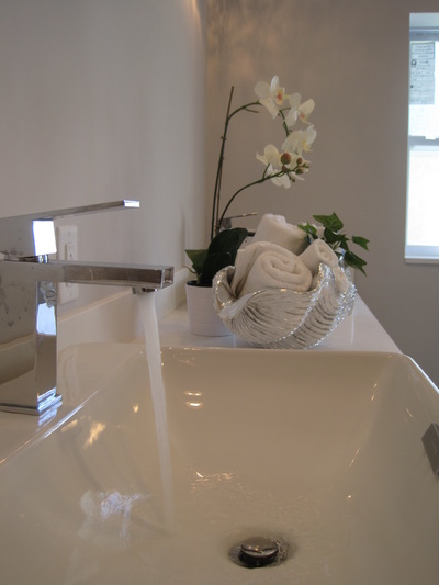 Fluffy white towels and greenery in a staged master bath, Pompano Beach Florida